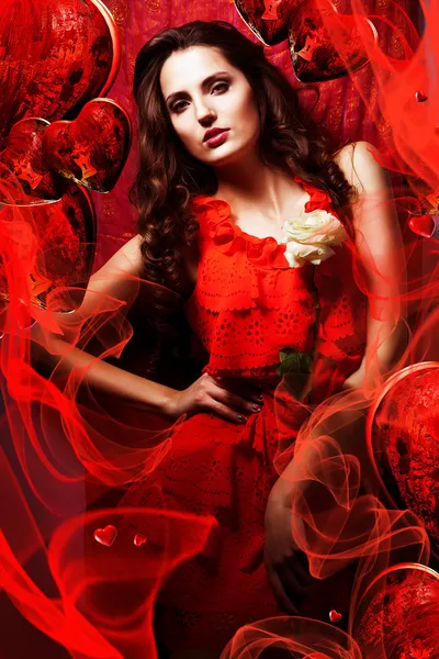 Beautiful hot woman in love in red dress around fabric and heart — Stock Photo, Image