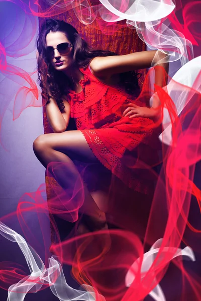 Femme brune en lunettes de soleil et robe rouge autour rouge et blanc — Photo