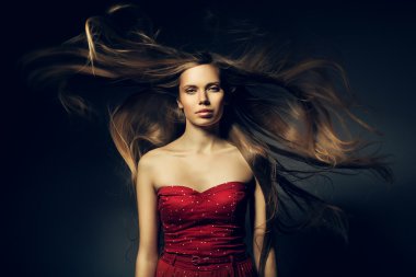 güzel bir kadın kırmızı ve uzun zaman rüzgarlı saçlarında
