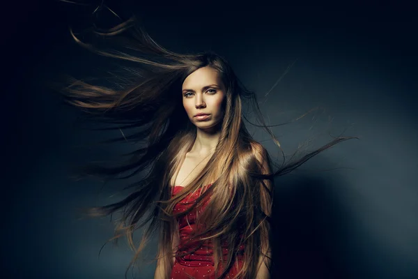 Hübsche Frau mit langen windigen Haaren — Stockfoto