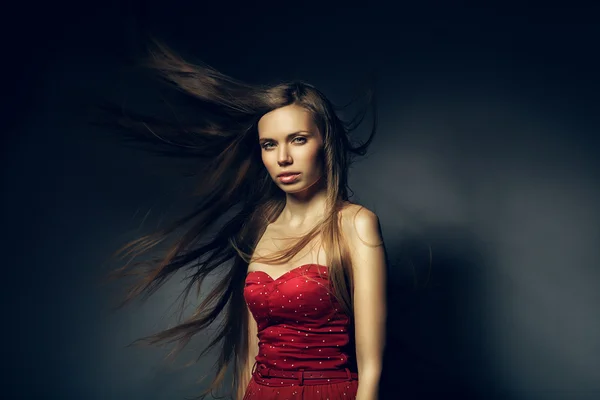 Bonita mujer en rojo con el pelo largo y ventoso — Foto de Stock