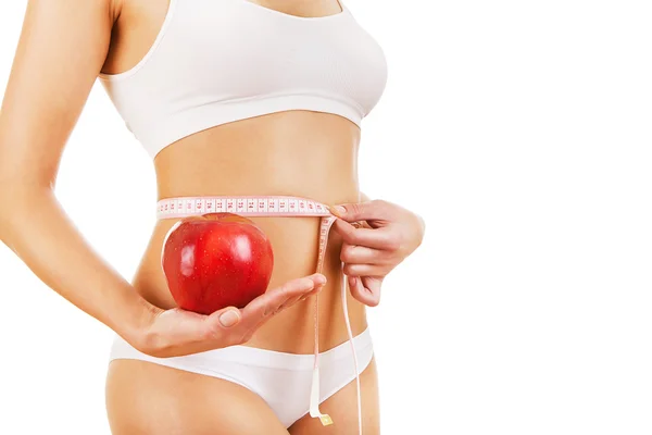 Sporty girl with measure in hands and apple — Stock Photo, Image