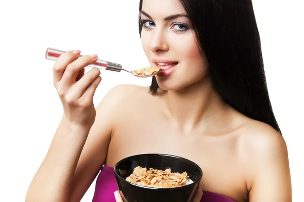 Woman in violet top eating corn flakes — Stock Photo, Image