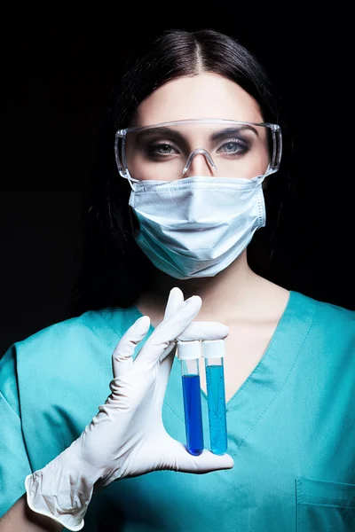 Attractive scientist holding tubes in dark — Stock Photo, Image