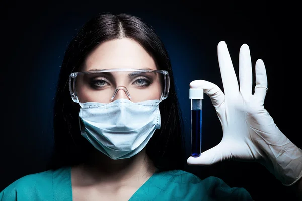 Attractive scientist holding tube in dark — Stock Photo, Image