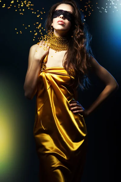 Femme en robe jaune et masque noir avec bijoux — Photo