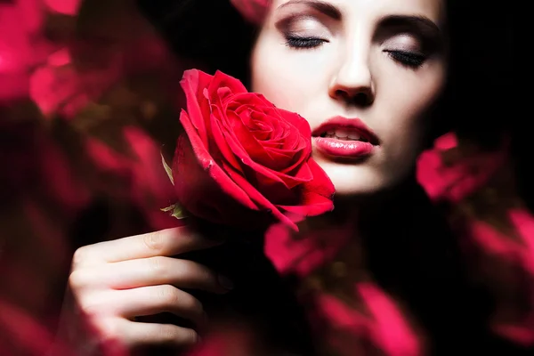 Aantrekkelijke vrouw met roos in de hand — Stockfoto