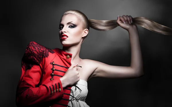 Sexig blond kvinna i röd jacka med röda läppar och lång svans — Stockfoto