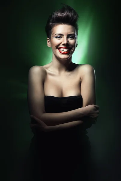 Smiling brunette woman with red lips in green light — Stock Photo, Image