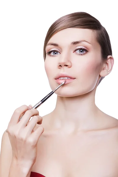Kvinna med kosmetiska borste på läppar — Stockfoto