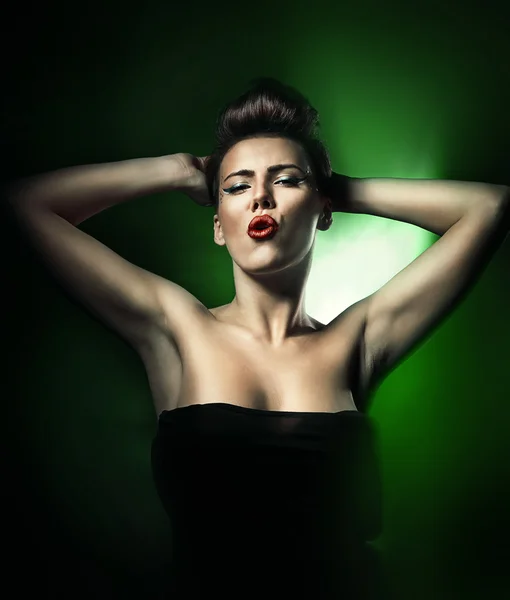 Hot beautiful woman with red lips in dark green light — Stock Photo, Image