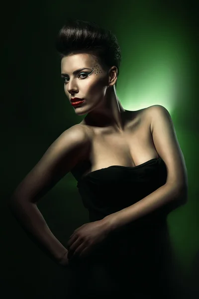 Pretty beautiful woman with red lips in dark green light — Stock Photo, Image