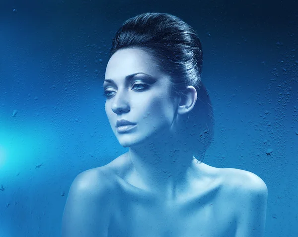 Brunette woman in dark blue shower Royalty Free Stock Images