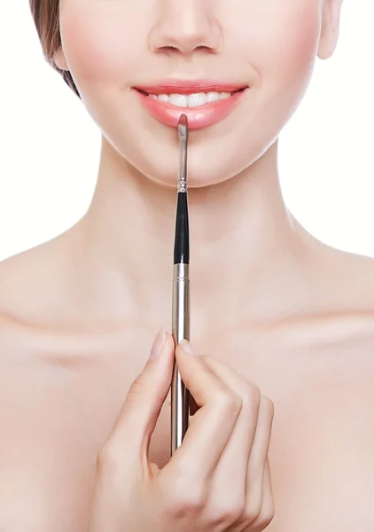 Cute woman with brush on lips — Stock Photo, Image
