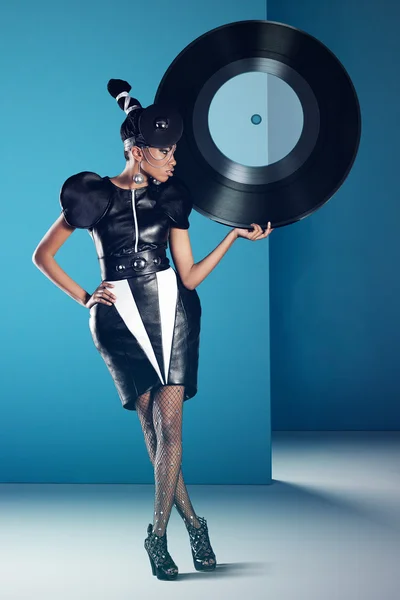 Disco african women stands with big vinyl record in her hand — Stock Photo, Image