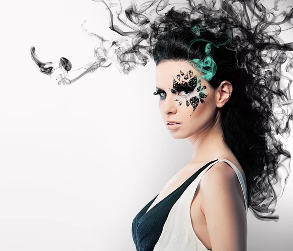 Face art of rhinestones on brunette woman and smoke — Stock Photo, Image