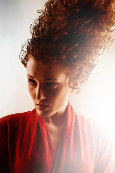 Modell i rött och lockigt hög hår — Stockfoto