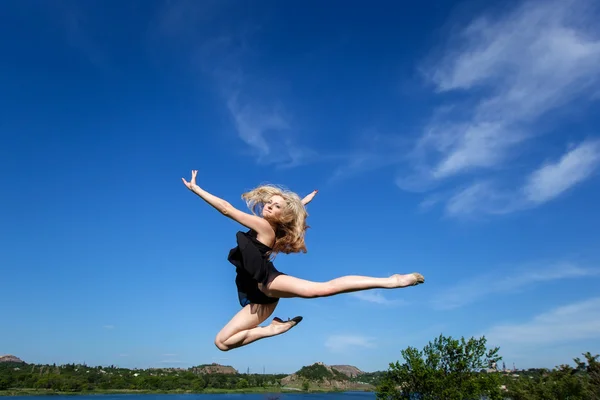 Il concetto di libertà. Ballerina che salta contro il cielo blu — Foto Stock