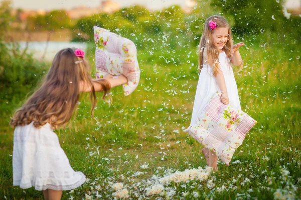 Adorable girls having fun with pillows outdoor — Stock Photo, Image