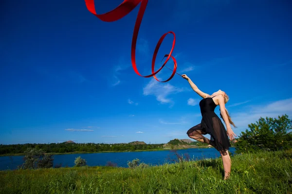 Joven gimnasta con una cinta al aire libre Fotos De Stock