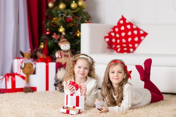 Christmas, x-mas, winter, happiness concept - two adorable curly girls playing with gift box — Stock Photo, Image