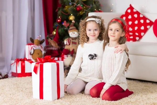 Christmas, x-mas, winter, happiness concept - two adorable curly girls playing with gift box — Stock Photo, Image