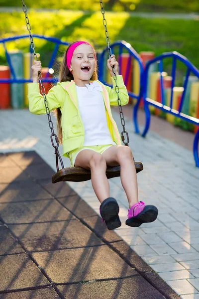 Cute girl having fun on a swing on summer day — Stock Photo, Image