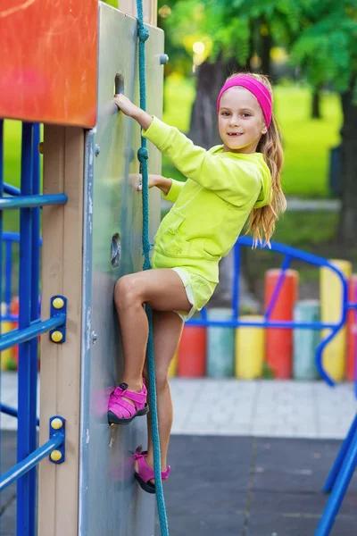 Klein meisje plezier in een speeltuin — Stockfoto