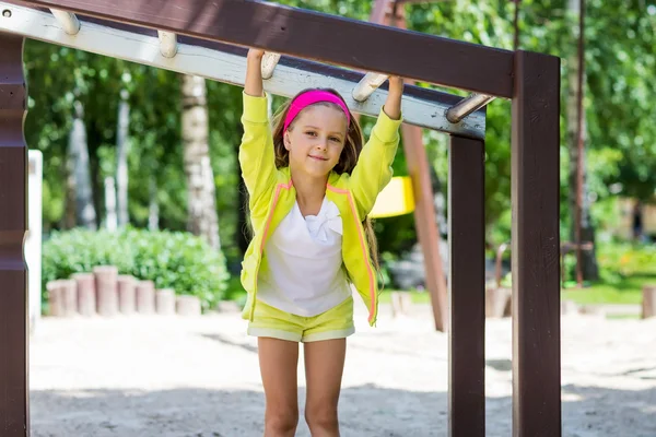 Petite fille aime jouer dans une aire de jeux pour enfants — Photo