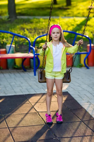 Leuk meisje op een schommel op zomerdag plezier — Stockfoto