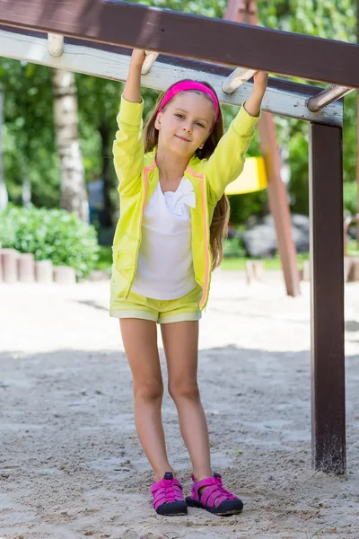 Malá holčička se těší, hraje v dětské hřiště — Stock fotografie