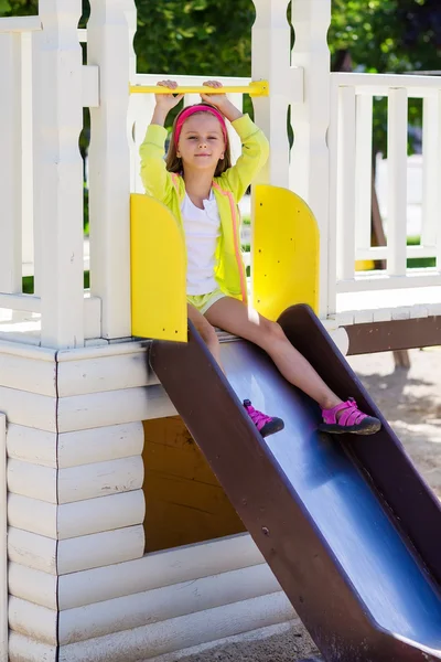 Petite fille aime jouer dans une aire de jeux pour enfants Photos De Stock Libres De Droits