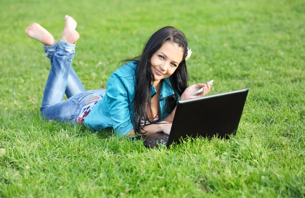 Frau im Gras mit Laptop — Stockfoto
