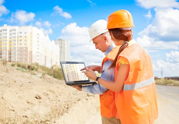 Werknemers in de bouw kijken naar lapto — Stockfoto