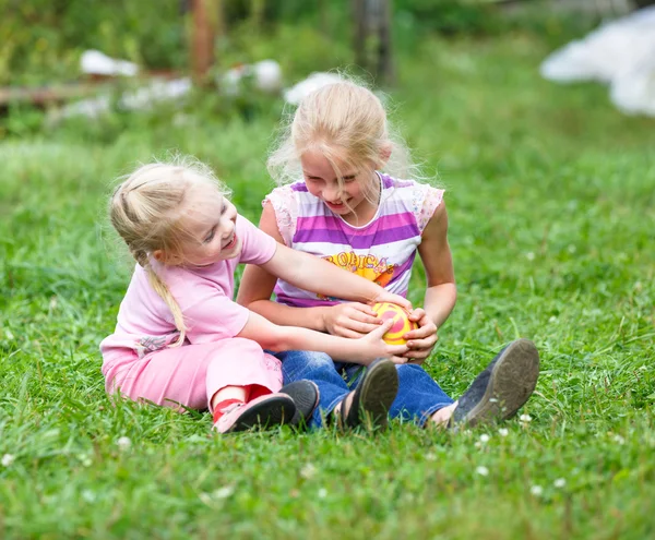 Две девушки играют на зеленой траве — стоковое фото