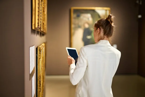 Woman visitor in the historical museum looking at pictures — Stock Photo, Image