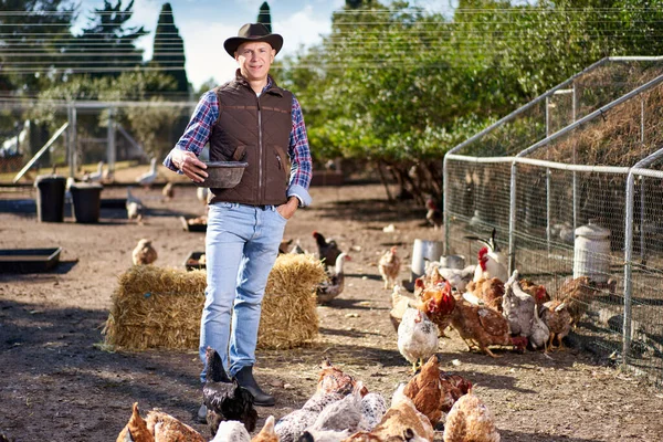 Agricultor alimentando chikens em um galinheiro — Fotografia de Stock