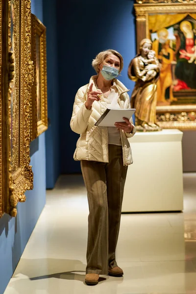 Portrait de femme adulte avec un guide regardant des photos au musée des arts — Photo