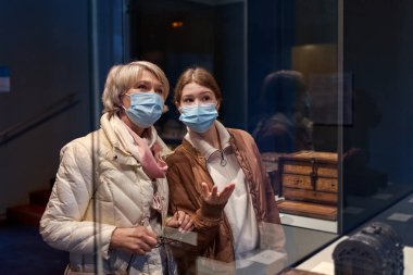 Kadın ve çocuk tarihi müzede eski sanat eserlerine bakıyor.