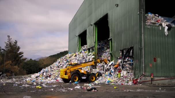 BARCELONA, SPANYOLORSZÁG - 2022. június 31.: Rakodó egy hulladékfeldolgozó üzemben — Stock videók