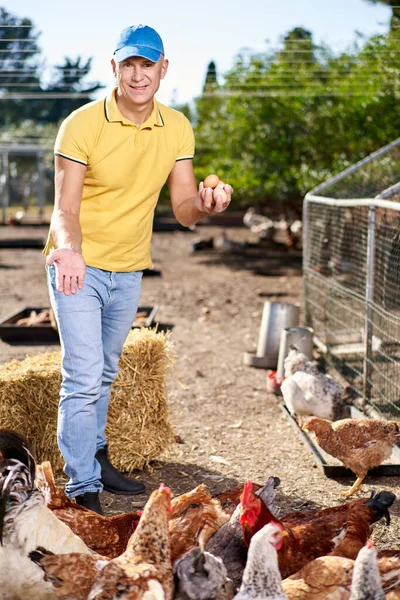 Šťastný farmář ukazuje kuřecí vejce — Stock fotografie