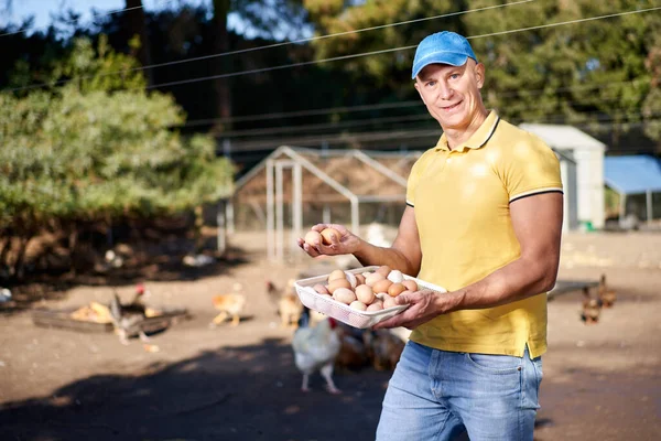 Glücklicher Bauer zeigt Hühnereier — Stockfoto