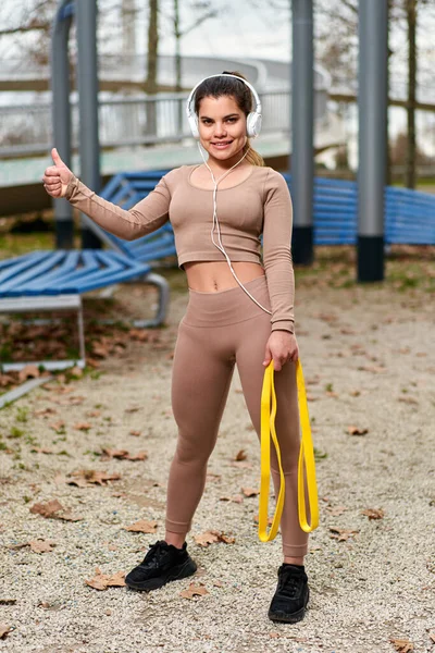 Kvinnan. Resistensband för konditionsträning. Fit Girl In Fashion Sporty Outfit Tränar utomhus. Urban människor och aktiv livsstil — Stockfoto