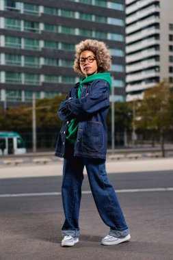 Çekici, kıvırcık saçlı, esmer bir kadının portresi.