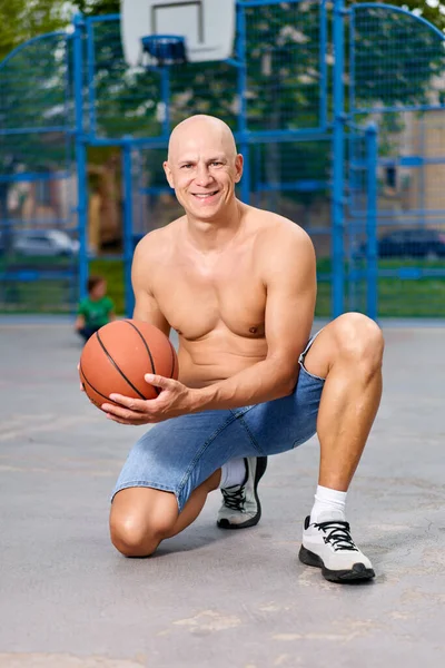 Knappe Man Die Een Basketbal Draagt Naar Camera Kijkt Stockfoto