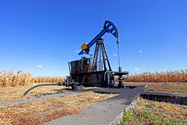 Pozo de petróleo en el campo de maíz — Foto de Stock