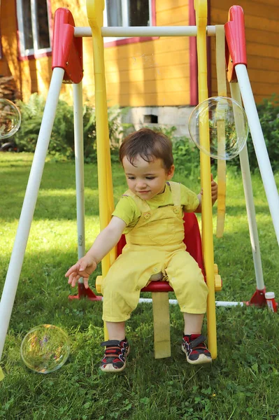 Child Swings Swing Plays Soap Bubbles — Stock Photo, Image