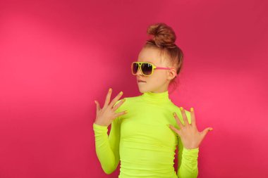 Sarışın bir kız sarı balıkçı yaka ve güneş gözlüğü takıyor..