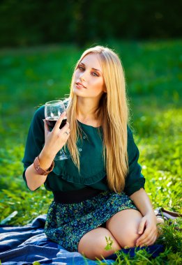 Kız bir kadeh şarap ile çim