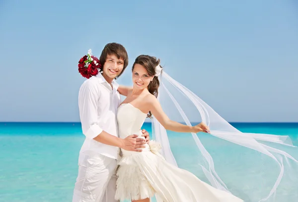 Happy bride and groom at the beach — Stock Photo, Image